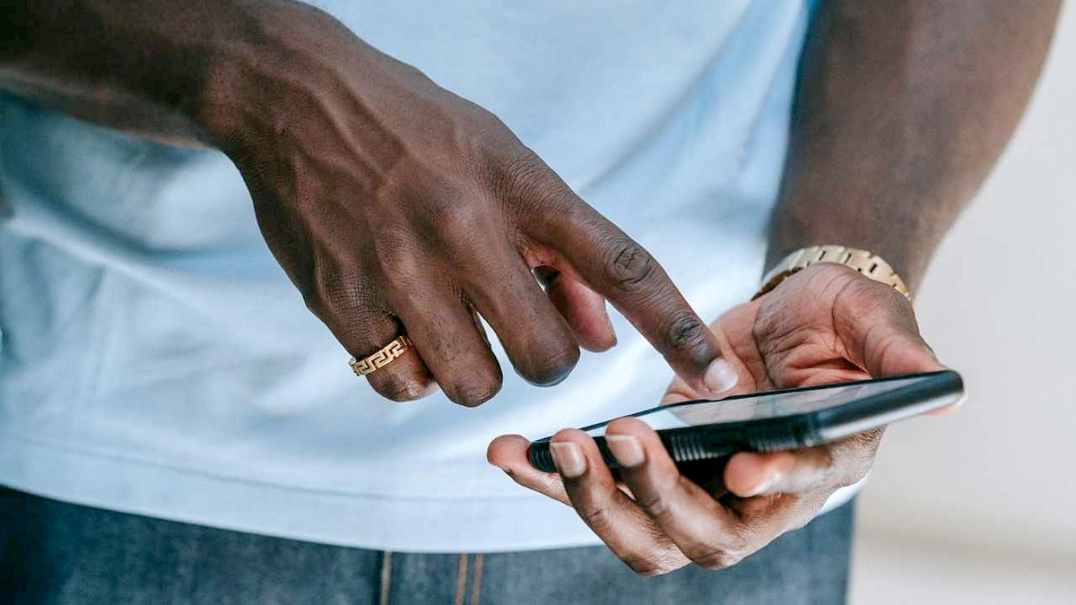 A man taps the screen of his smartphone.